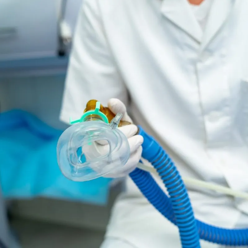 Someone placing an anesthesia mask